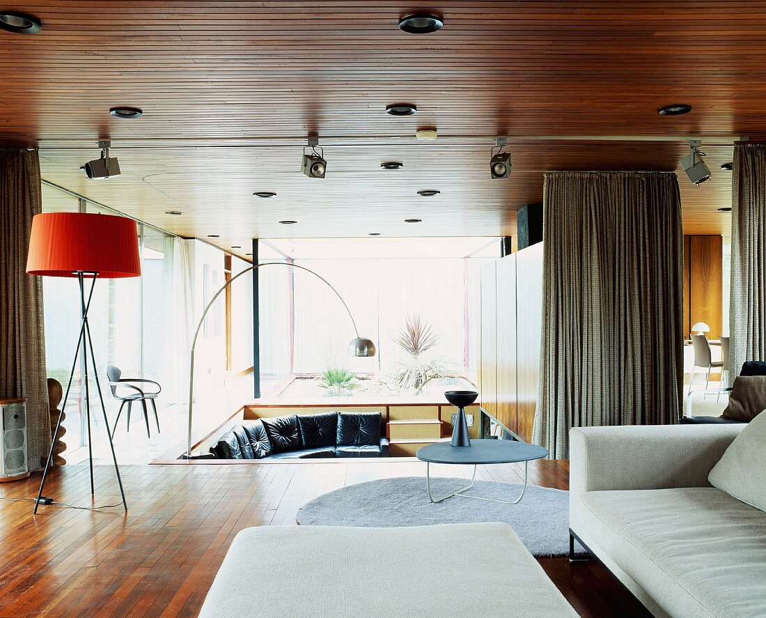 Grosszügiger offener Wohnraum mit heller Couch und verschiedenen Stehlampen aus Bauhauszeit