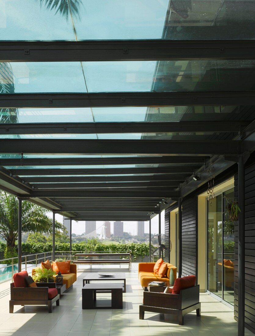 Glasüberdachte Terrasse mit Lounge-Möbeln