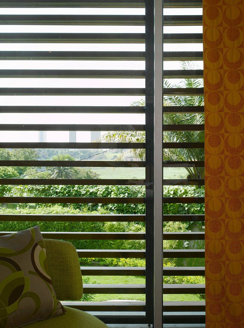 70s patterns in front of sun shade louver blinds with view of palm tree