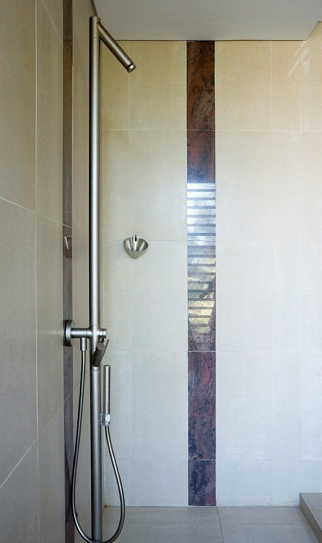 Shower with sunken base, designer fittings and vertical tiling trim in dark marble