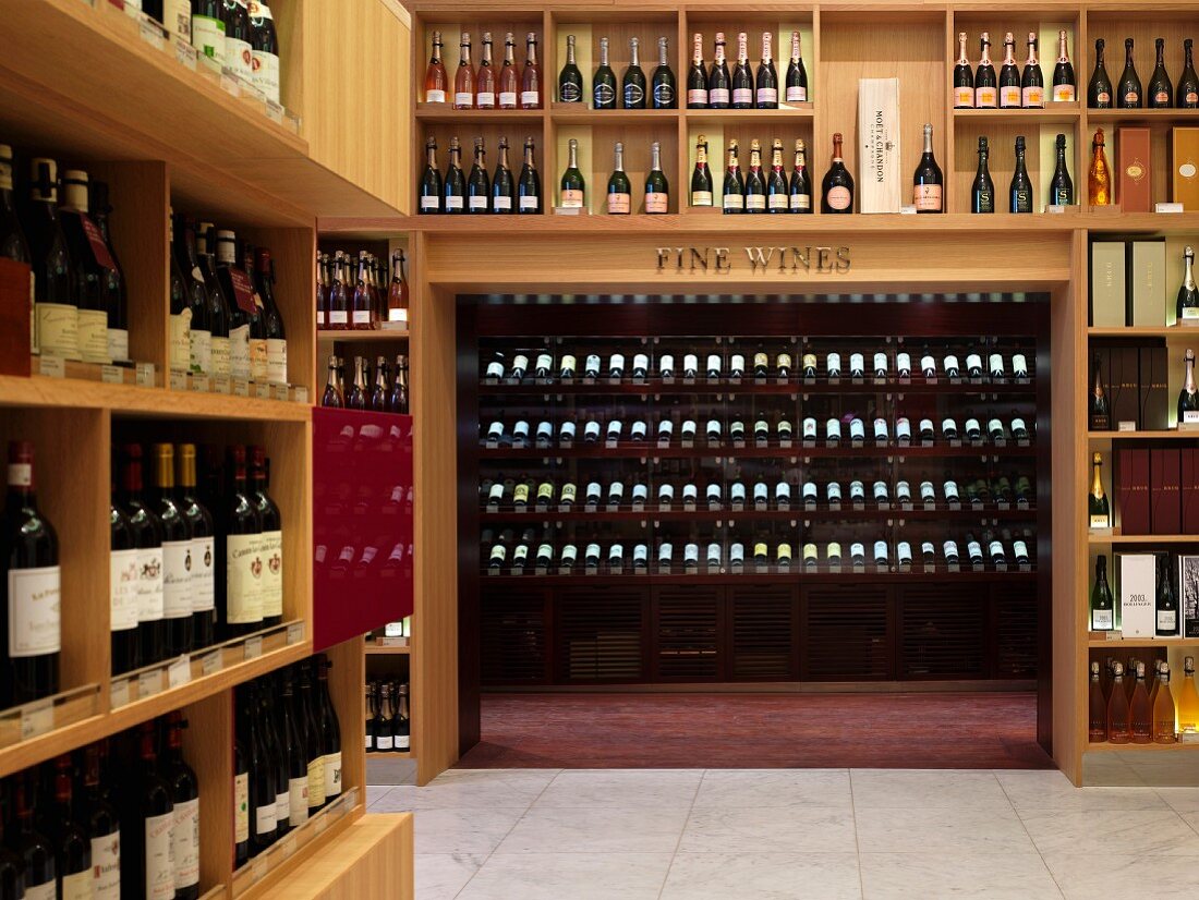Verkaufsraum einer edlen Weinhandlung mit raumhohen Flaschenregalen aus Holz