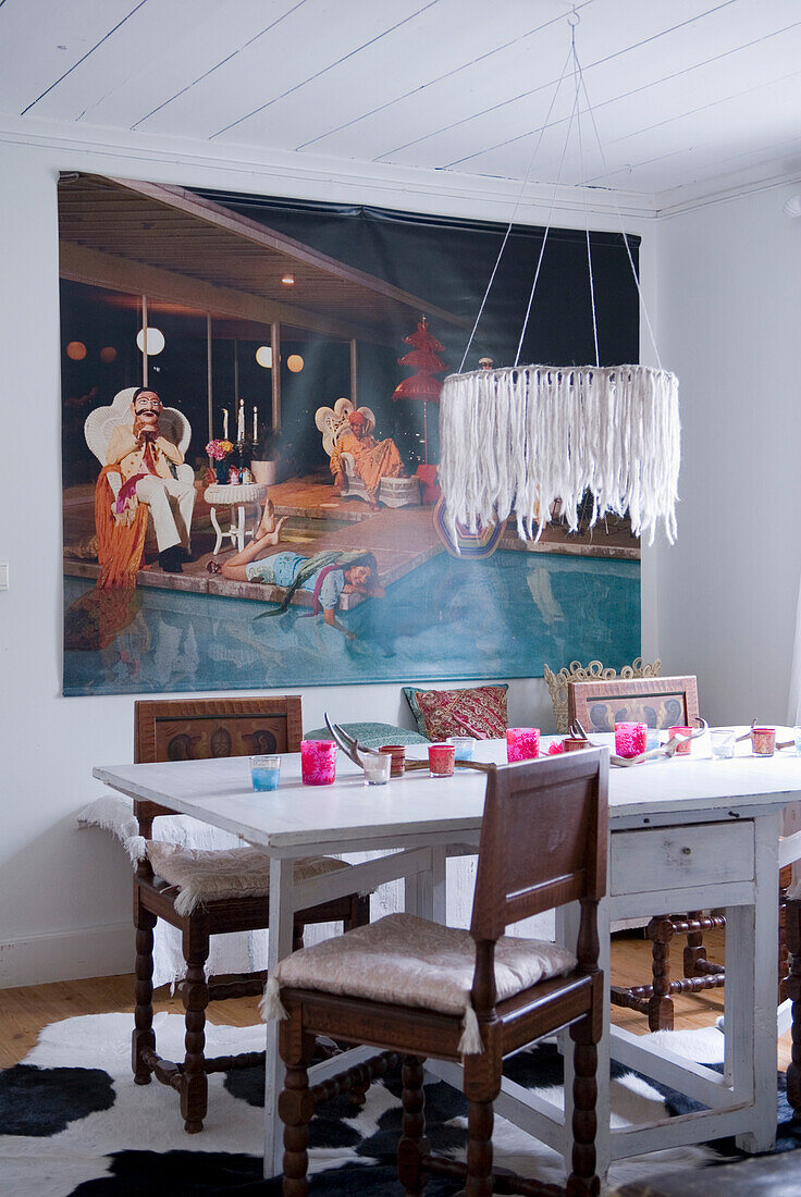 Dining table with historic chairs, mural and extravagant hanging lamp in the dining room