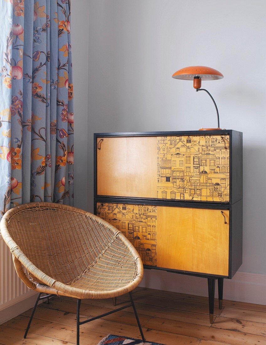 Bamboo armchair in front of wall cabinet with lamp