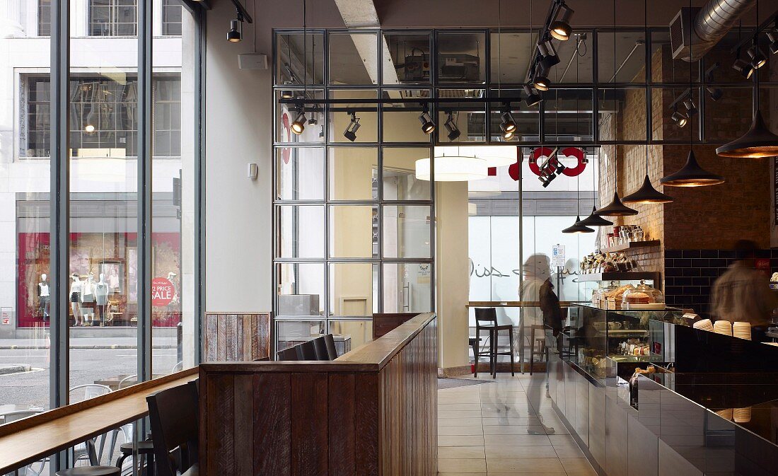 Industrieller Stil in aufgeglaster Londoner Coffee Bar mit Beleuchtungskonzept aus Hängelampen und Deckenstrahlern
