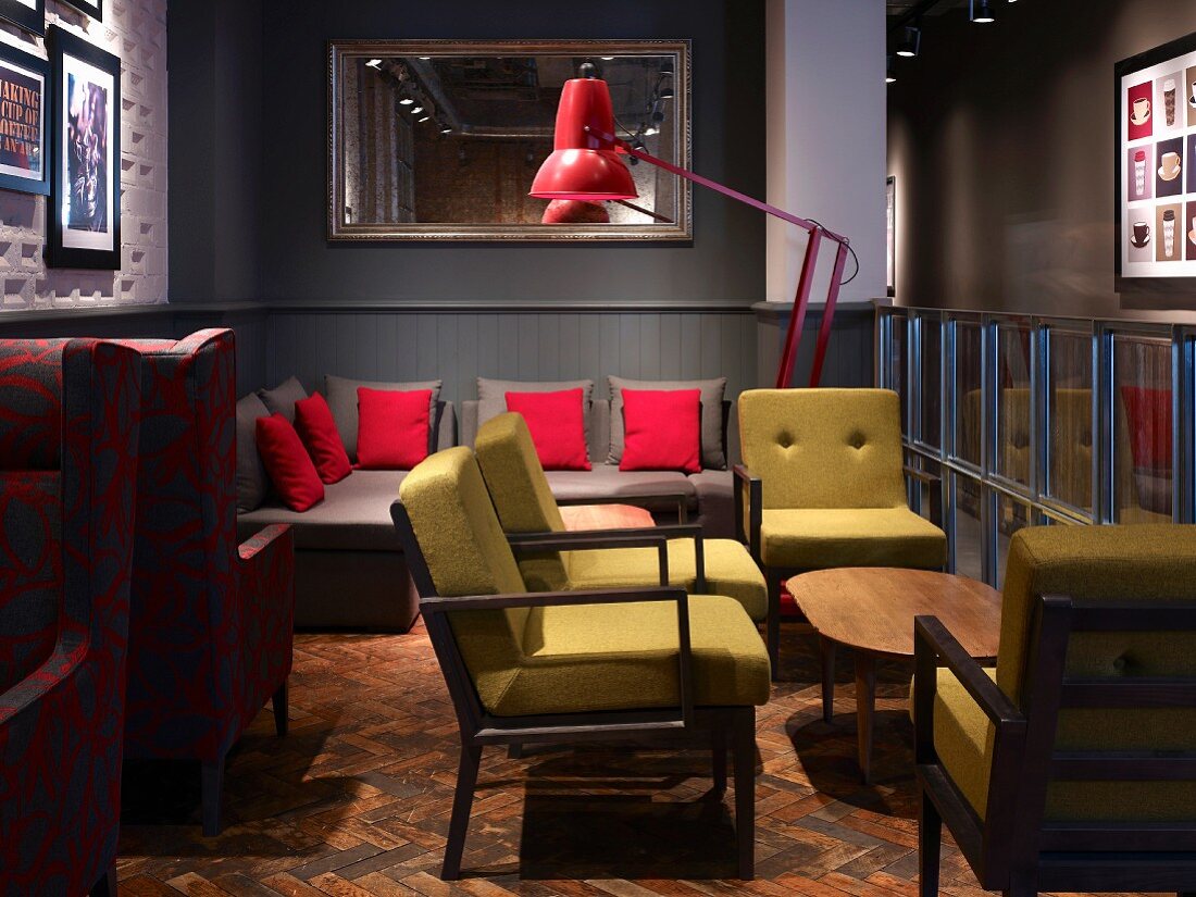 Sitzgruppen Stilmix mit bequemen Retro Polstermöbeln auf abgenutztem Fischgrätparkett in englischer Coffee Bar