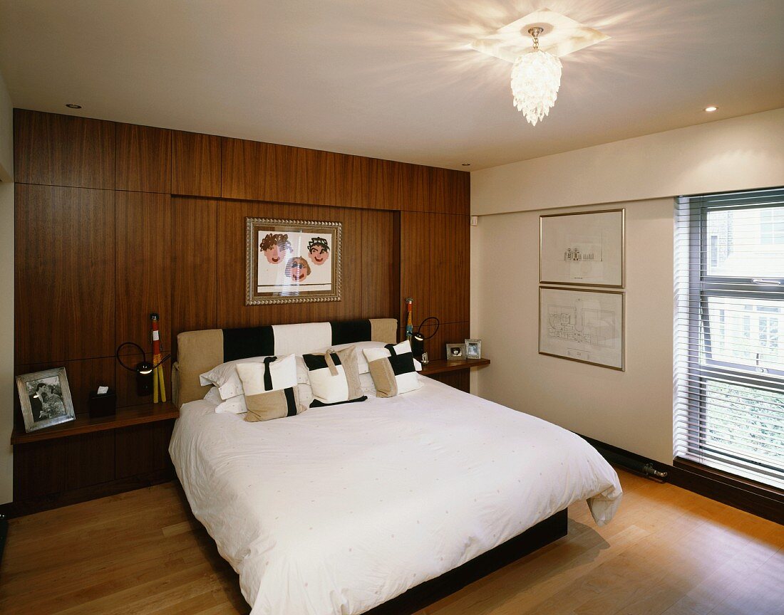 Modern bedroom with double bed in front of wood-panelled wall