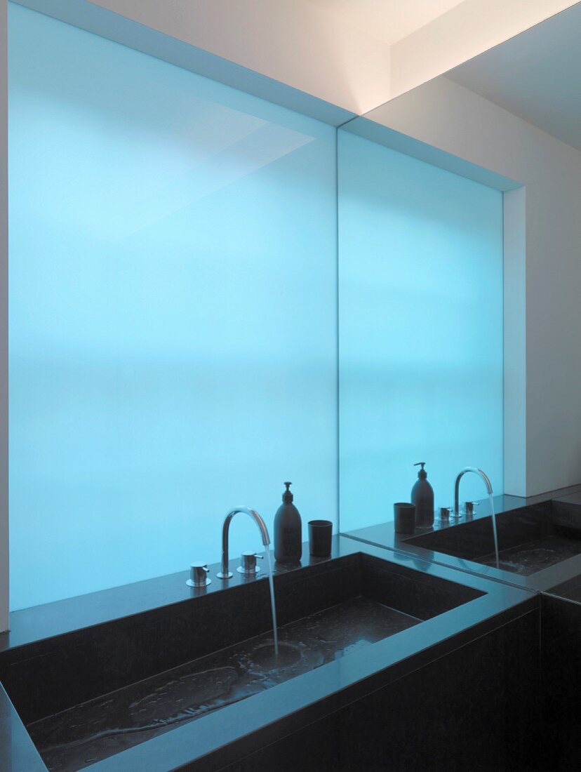 Designer-Waschbecken vor blauer Glaswand
