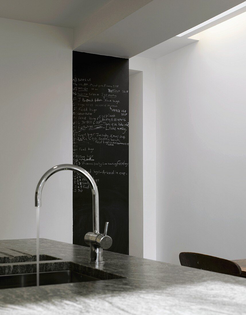 Sink with modern tap, slate message board in background