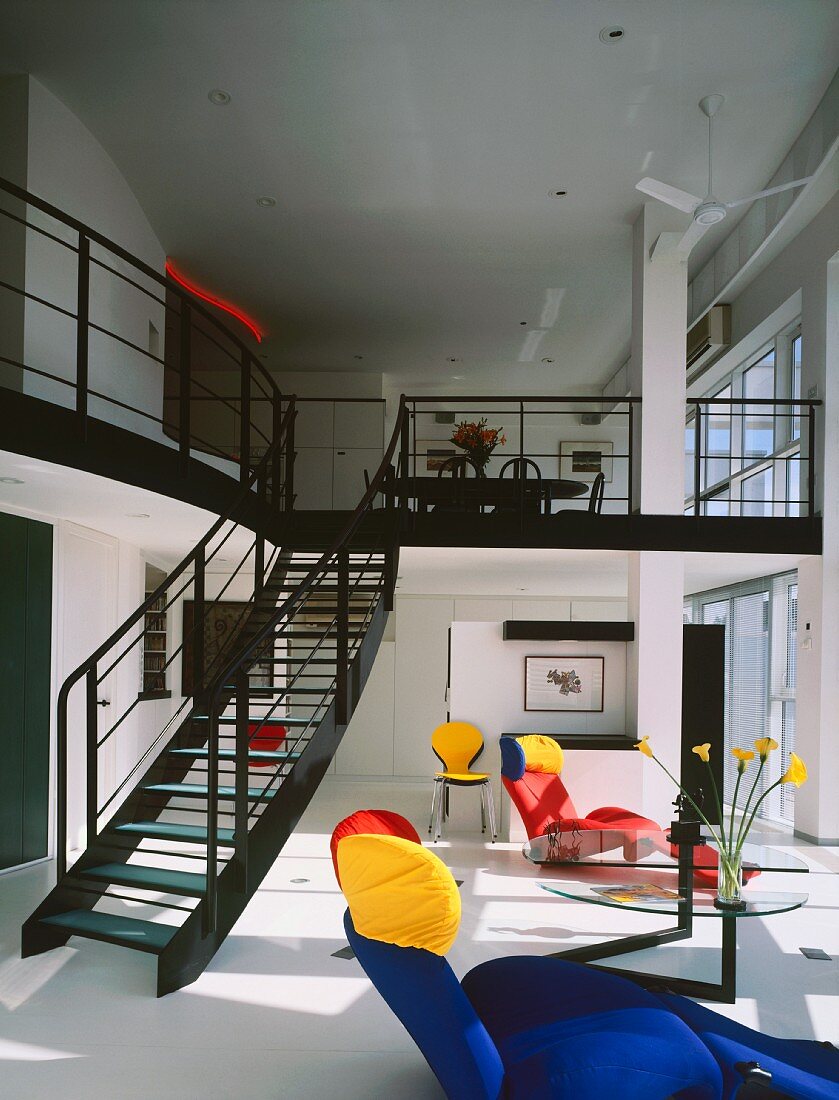 Living room with colourful seating & stairs to gallery