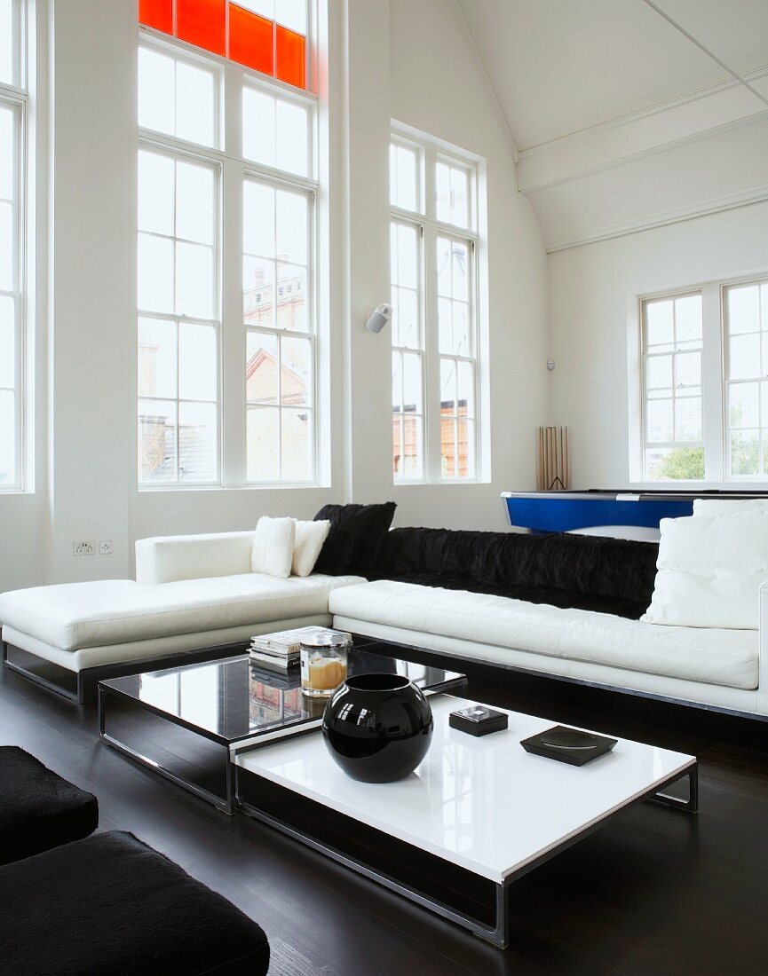 Wohnzimmer mit Sofa, Couchtisch & raumhohen Fenstern