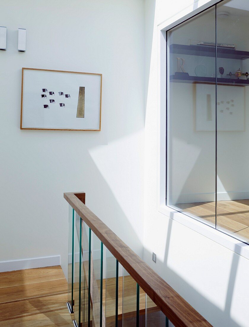 Contemporary stairwell with ceiling-height windows and view of room
