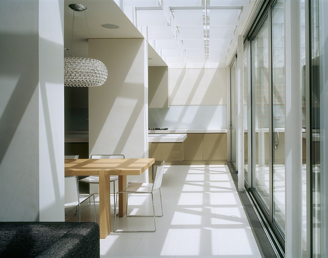 Offener Wohnraum mit Küche, Essbereich und Wohnzimmer und Glasfront zu der Terrasse
