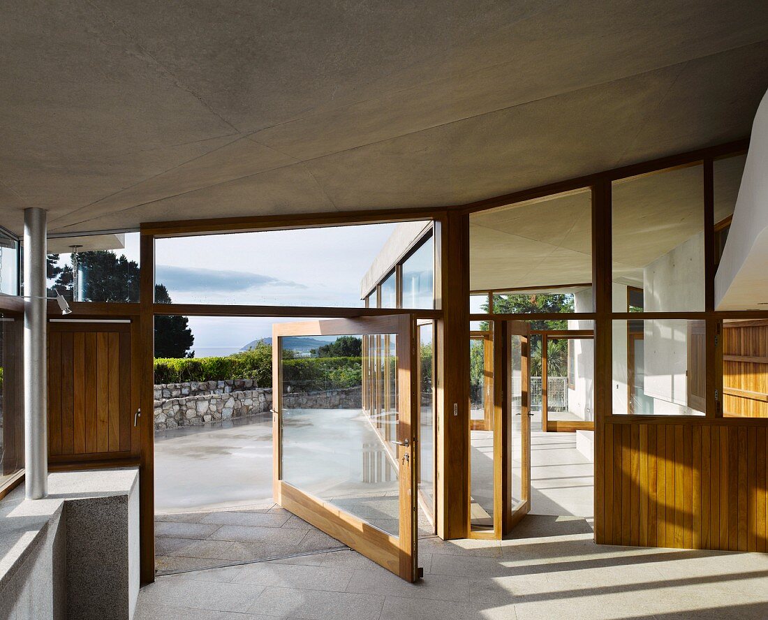 Zeitgenössisches Haus mit offener Terrassendrehtür und Blick auf die Landschaft