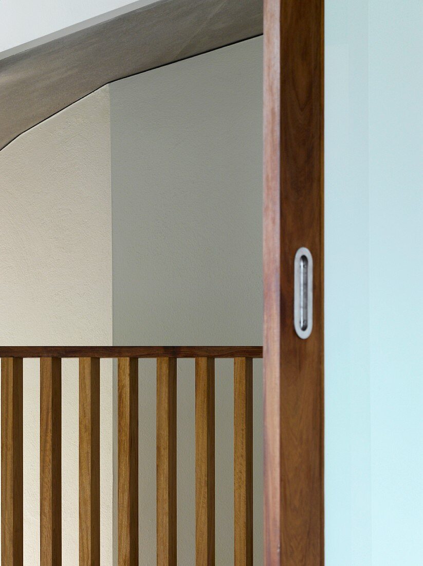 View of wooden balustrade through open sliding door