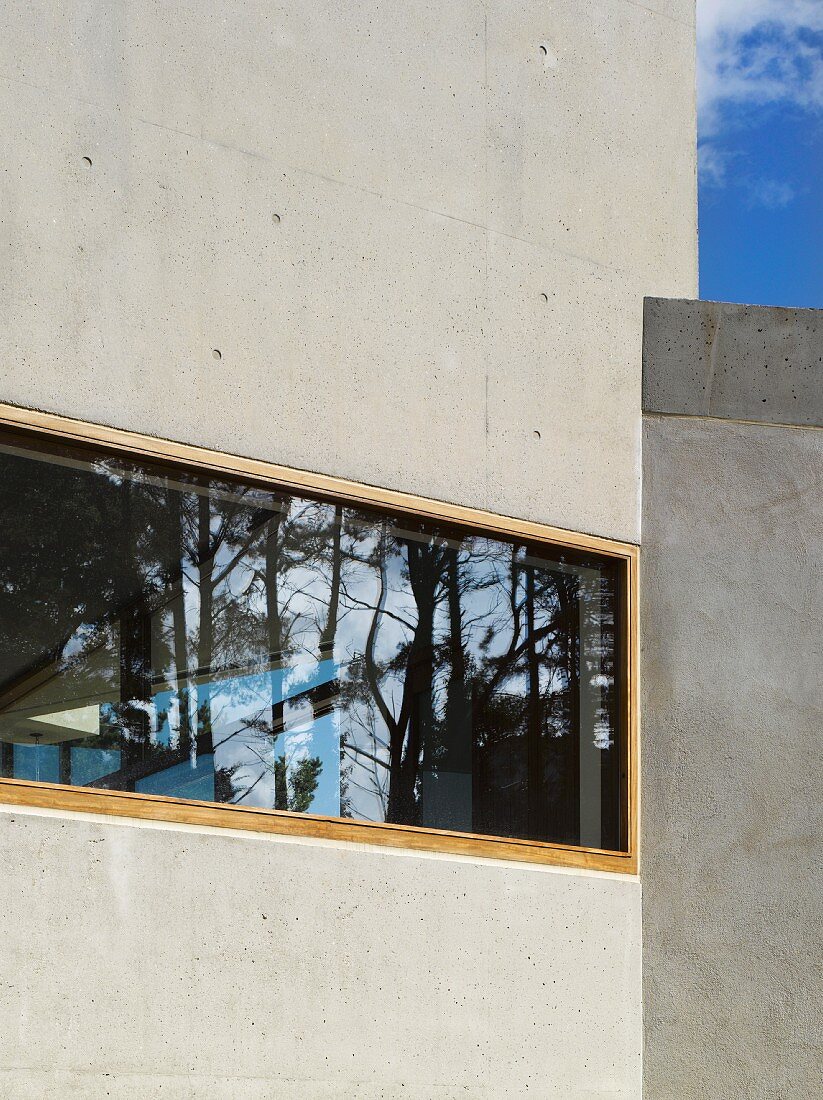 House facade of exposed concrete with horizontal window