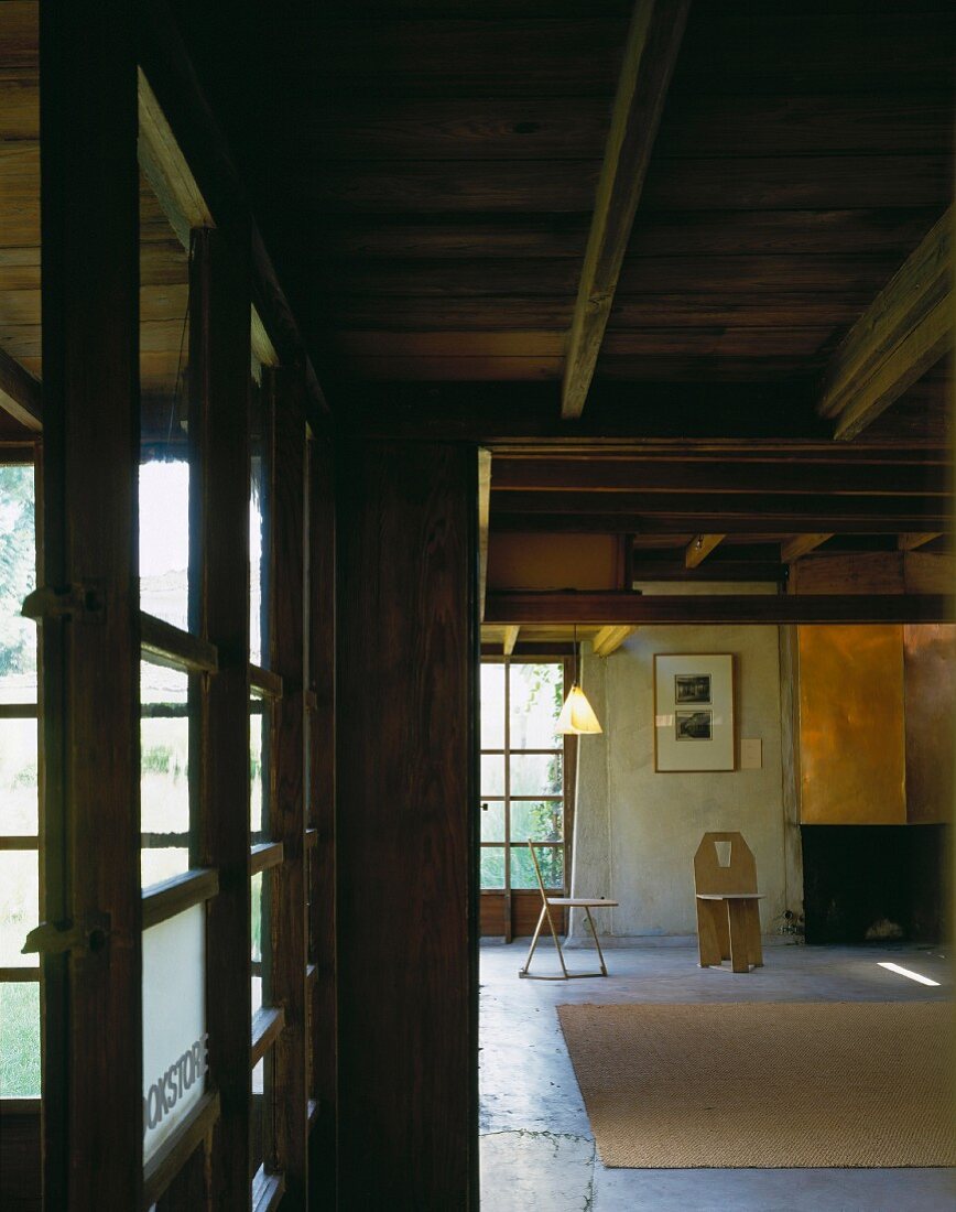 Wohnhaus mit Holzbalkendecke und minimalistisch eingerichtetem Wohnraum