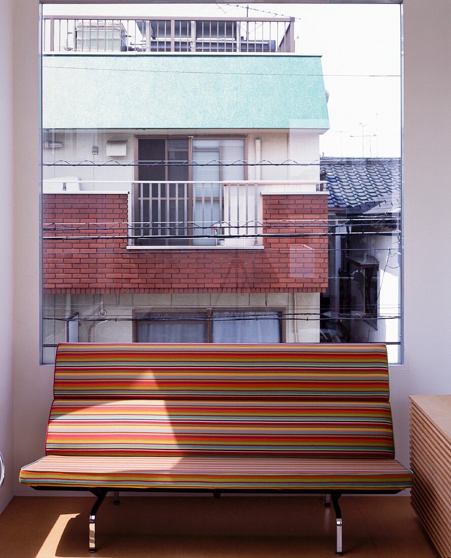 Striped bench in front of large window