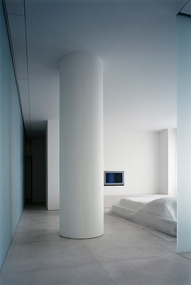 Round, white column in minimalist bedroom