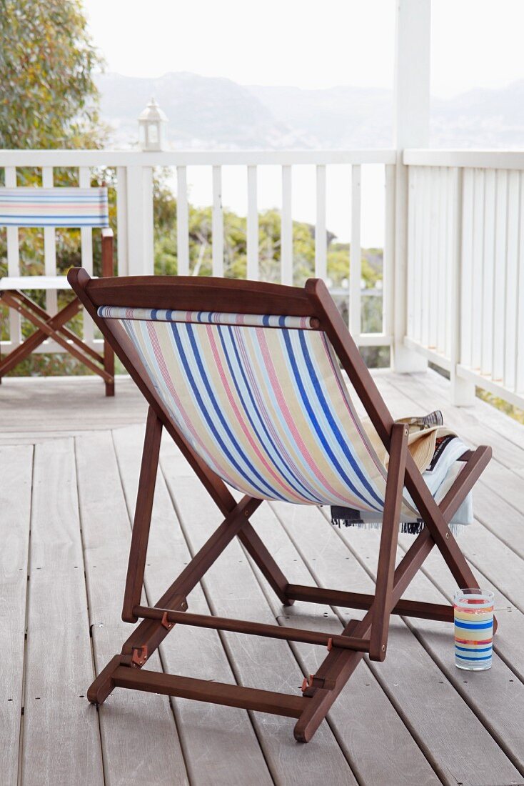 Deckchair with wooden frame and striped seat on a roof terrace
