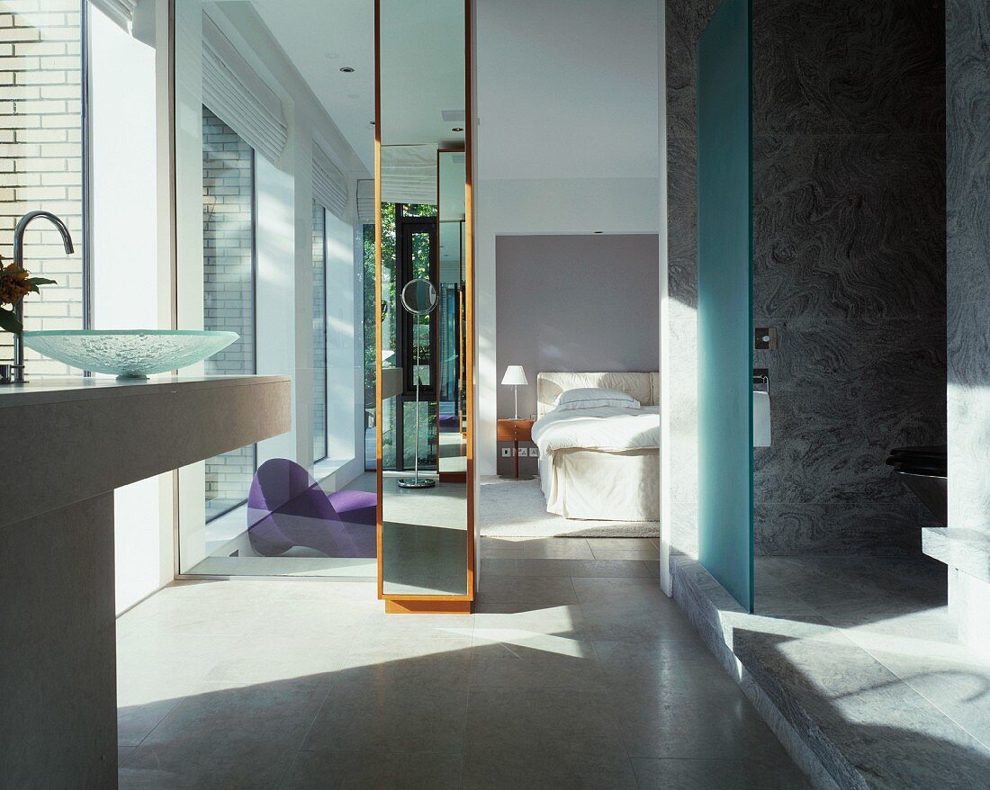 Ensuite bathroom with marble shower area and view of bed through ceiling-height doorway