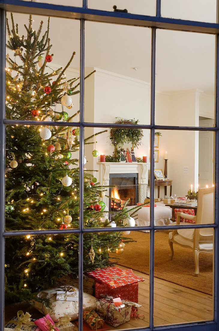 View of decorated Christmas tree in traditional setting through lattice window