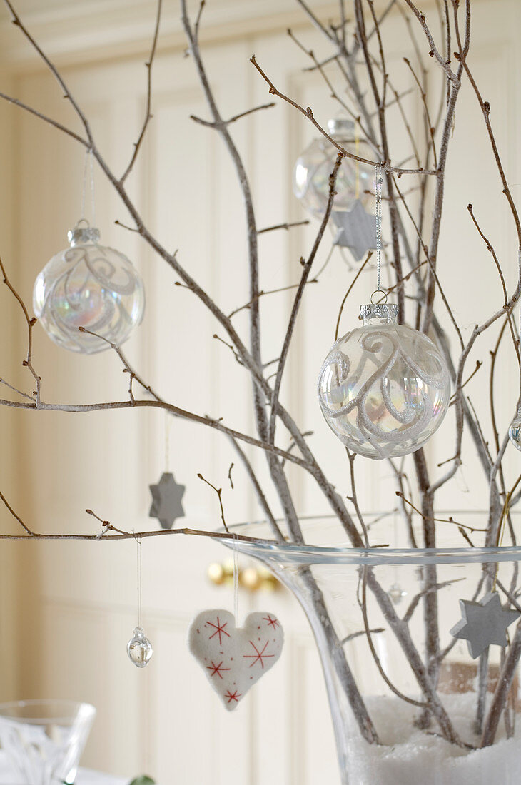 Christmas baubles and decorations hanging on twigs