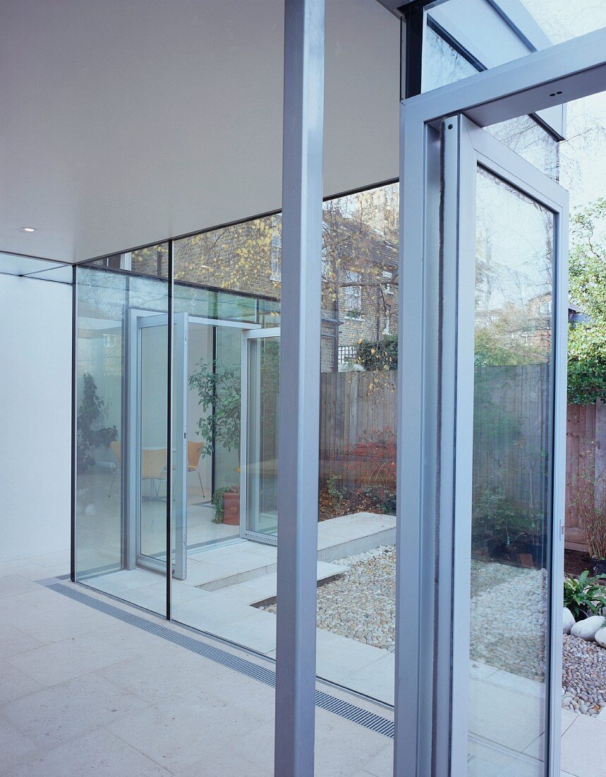 Glastüren und Glaswände trennen den Wohnbereich vom Garten