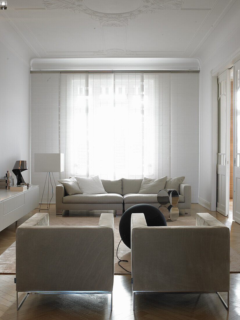 Brightly decorated living room with stucco ceiling and elegant furniture