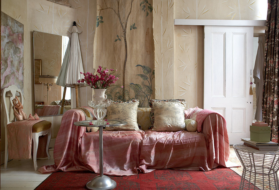 Sofa mit rosafarbenem Überwurf in ländlichem Wohnraum