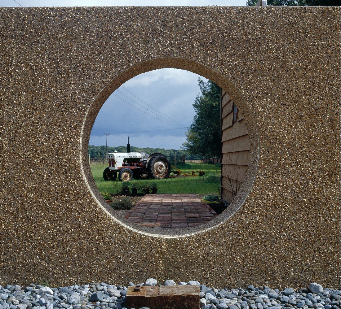 View of tractor through round cut-out in wall