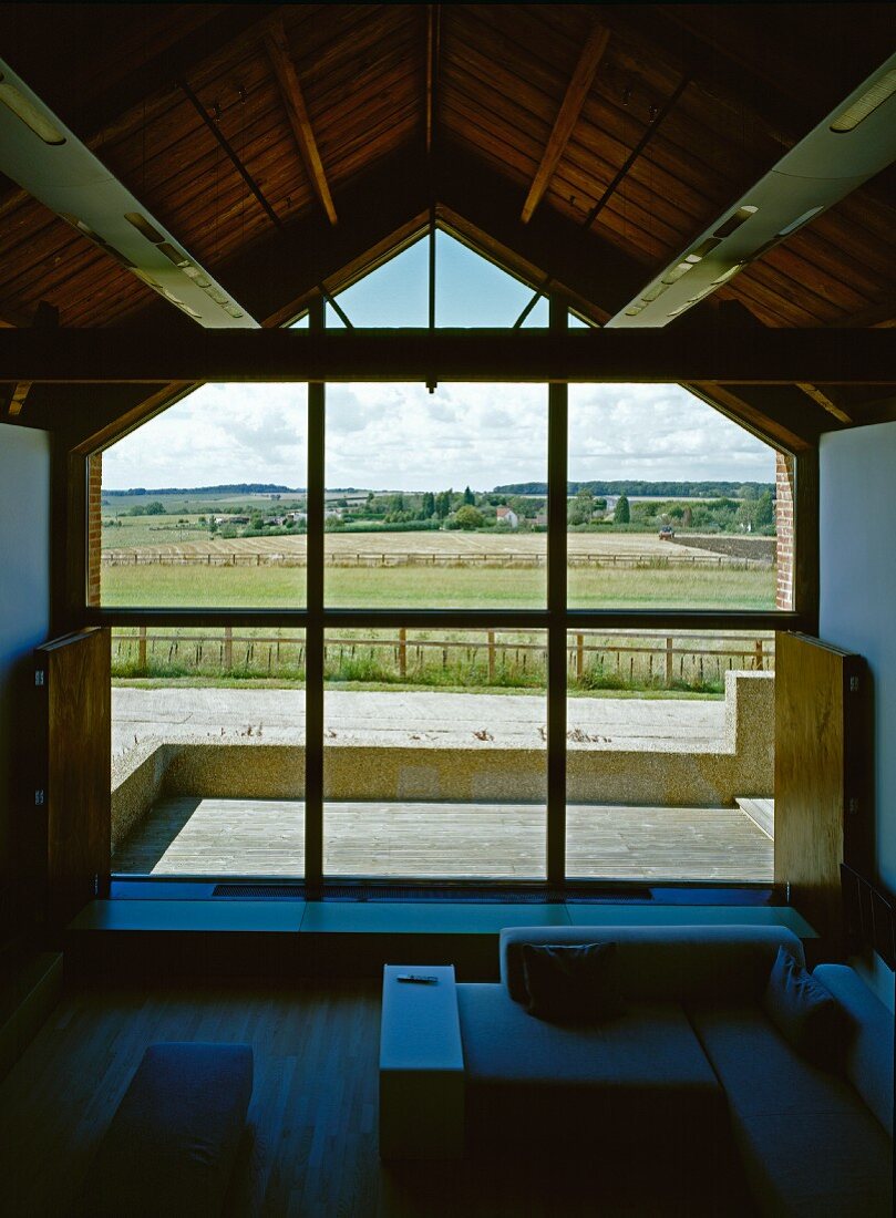 Blick aus dem Wohnzimmer durch die Glasfront auf den Hof