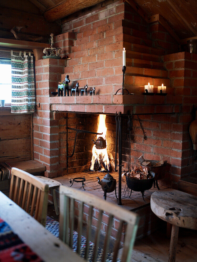 Offener Kamin mit Feuer im rustikalen Landhausstil