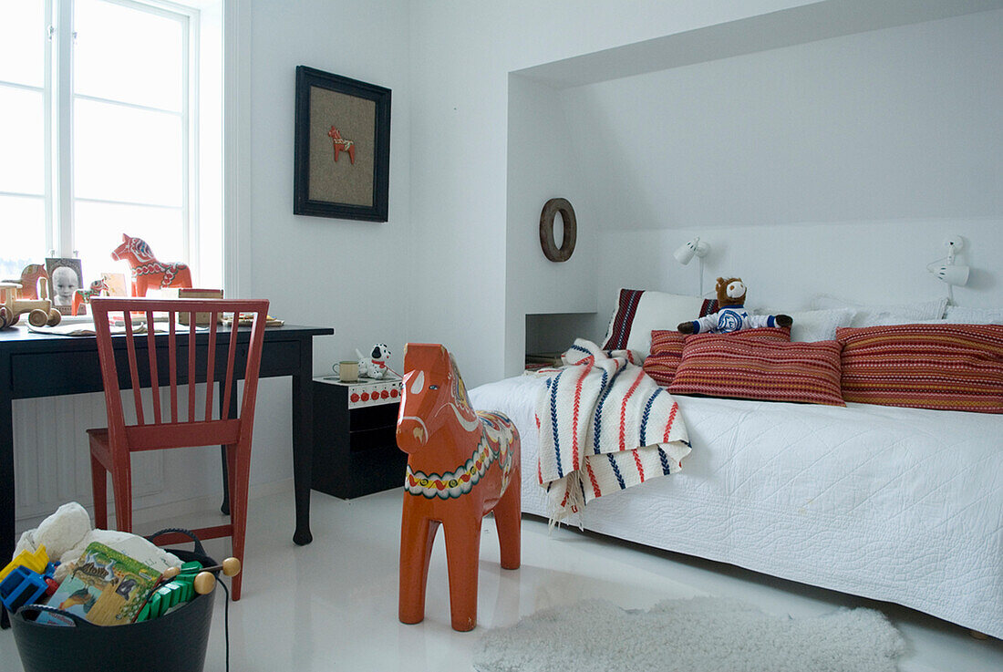Children's room with white bed, dala horse and basket with toys