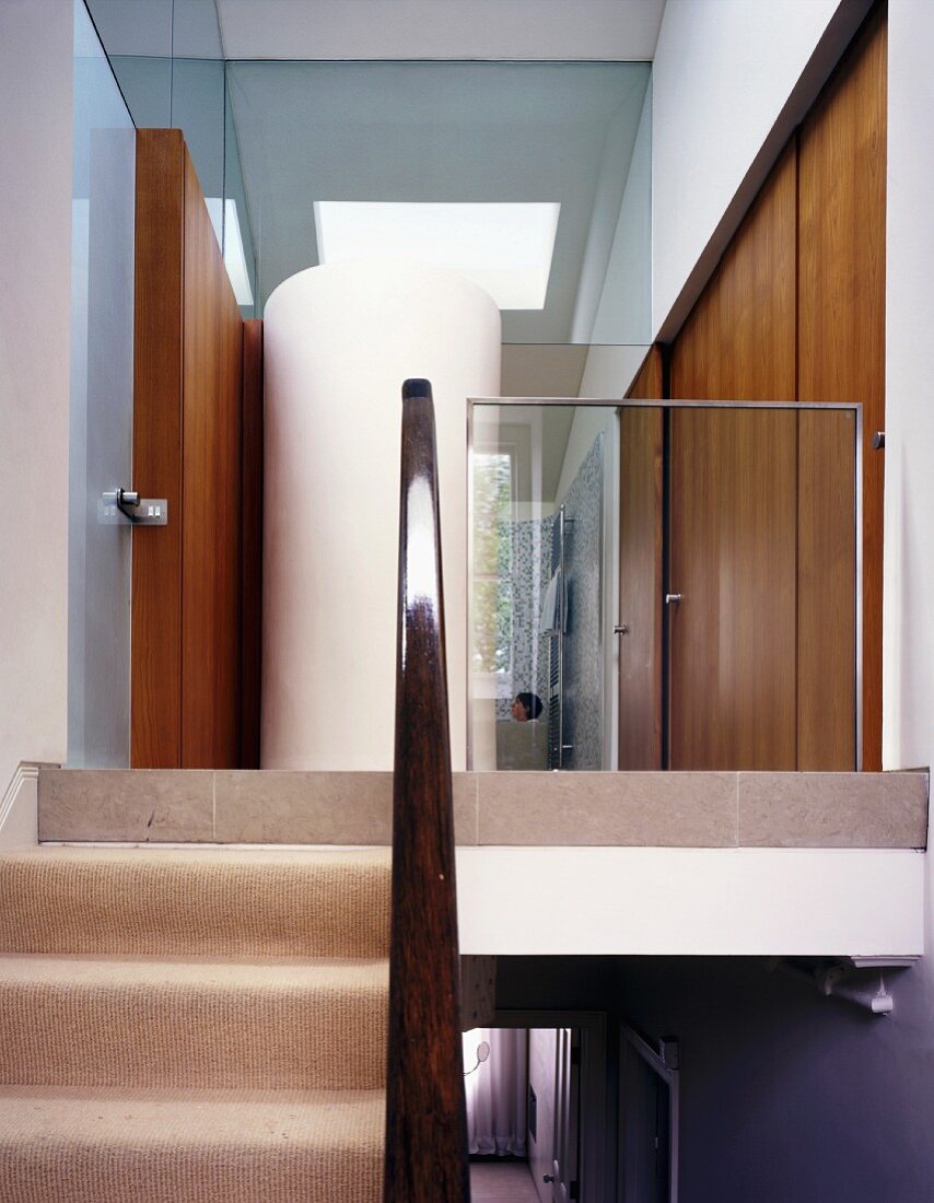 Treppenaufgang mit Blick auf zylinderförmigen Einbau auf Podest