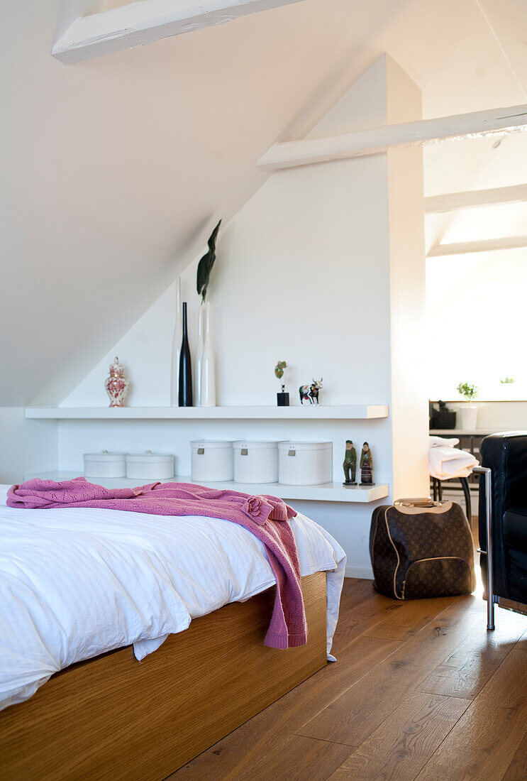 Bedroom with sloping ceiling, white furnishings and pink ceiling