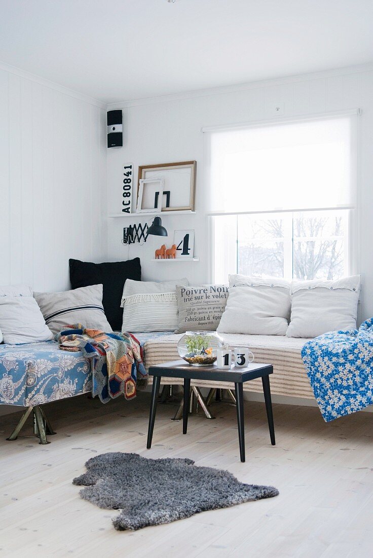 Comfortable, vintage-style corner sofa with scatter cushions and blankets