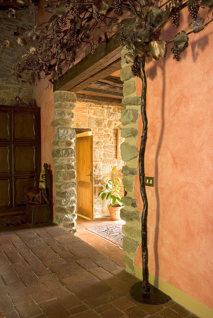 Country-style hallway with stone walls and grapevine decoration