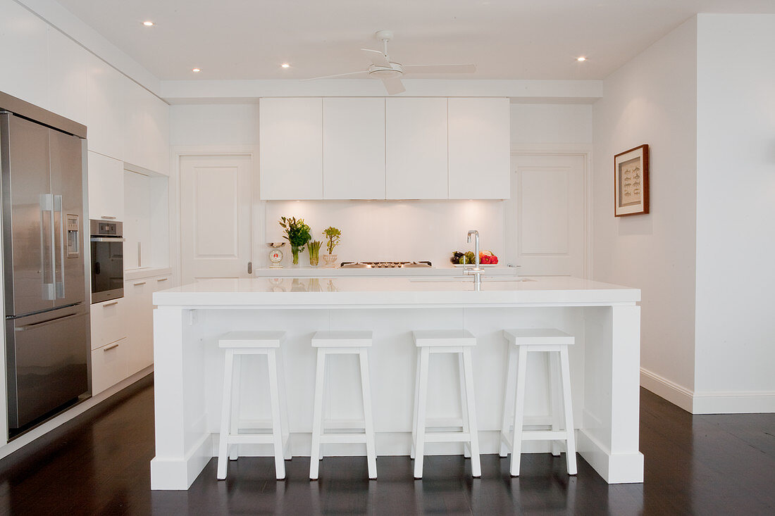 Designer kitchen with white island and retro bar stools