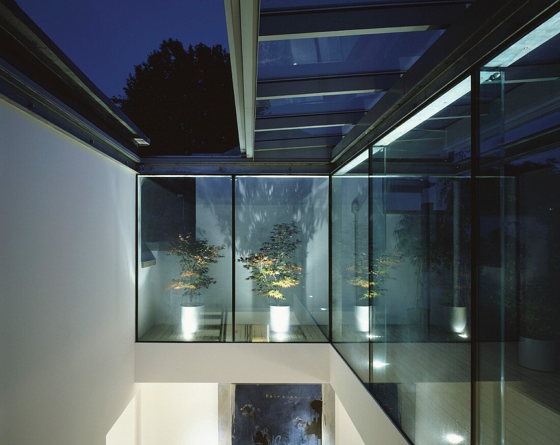 Nach oben offener Raum mit verschiebbarem Glasdach und Blick in die Nachtstimmung
