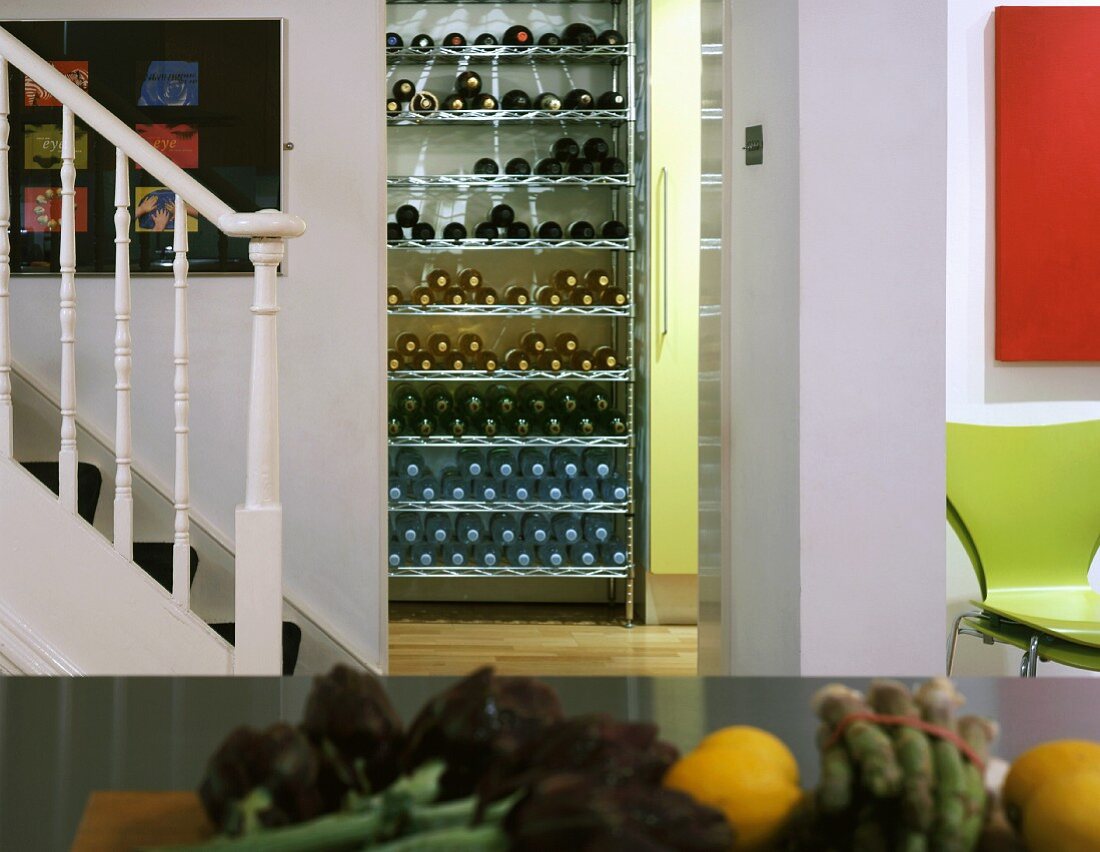 Staircase in kitchen and view of wine rack through doorway