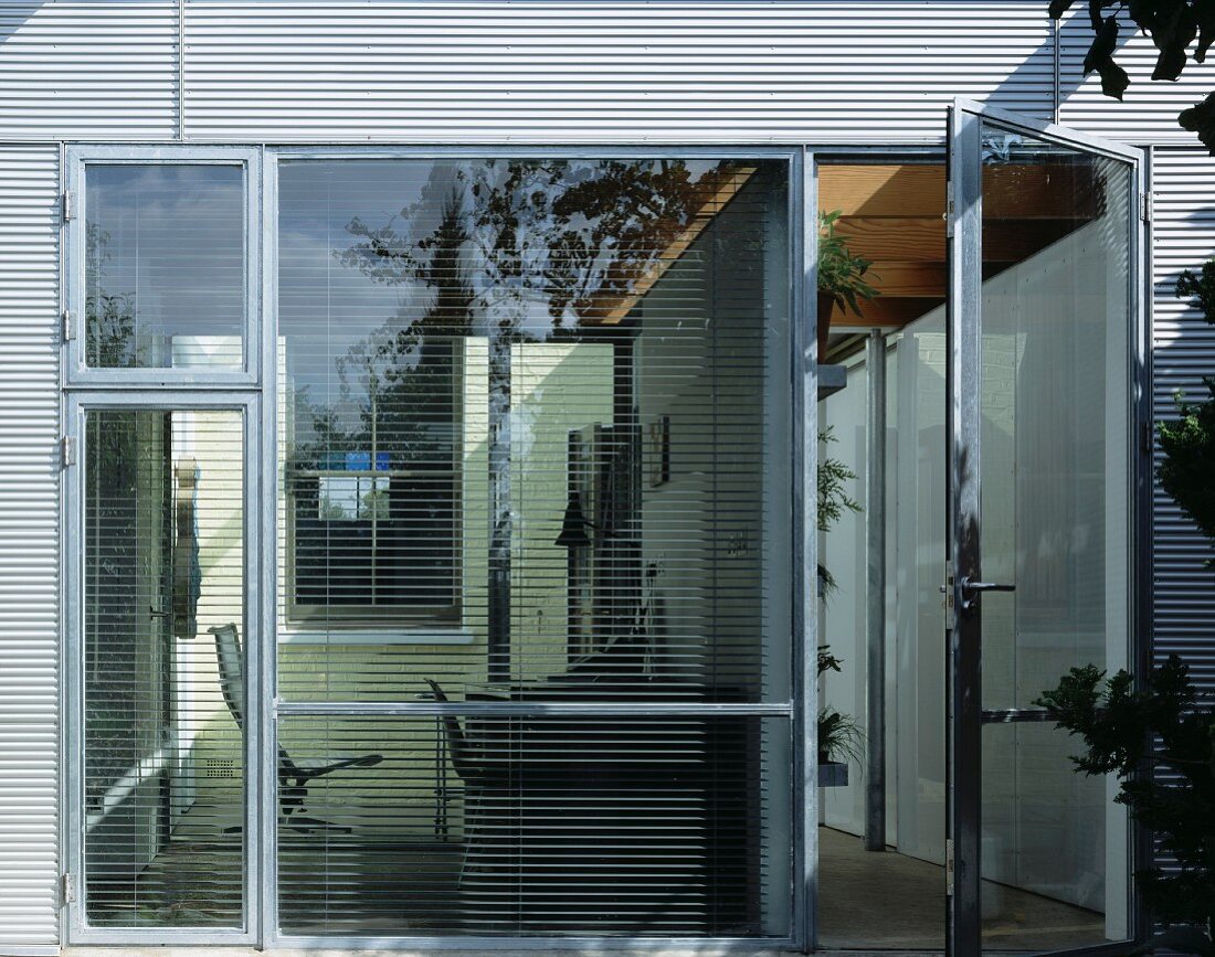 Glass wall with terrace door and closed louver blinds