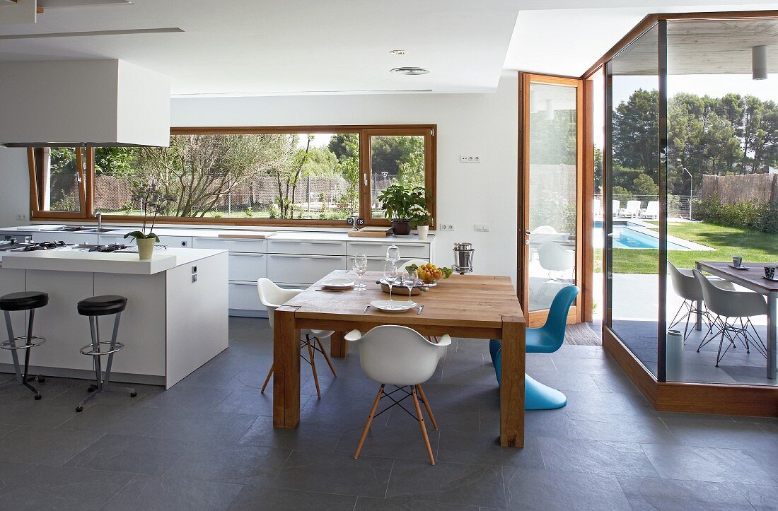 Moderne Küche und Essbereich mit Schieferboden und verglaster Terrassenfront