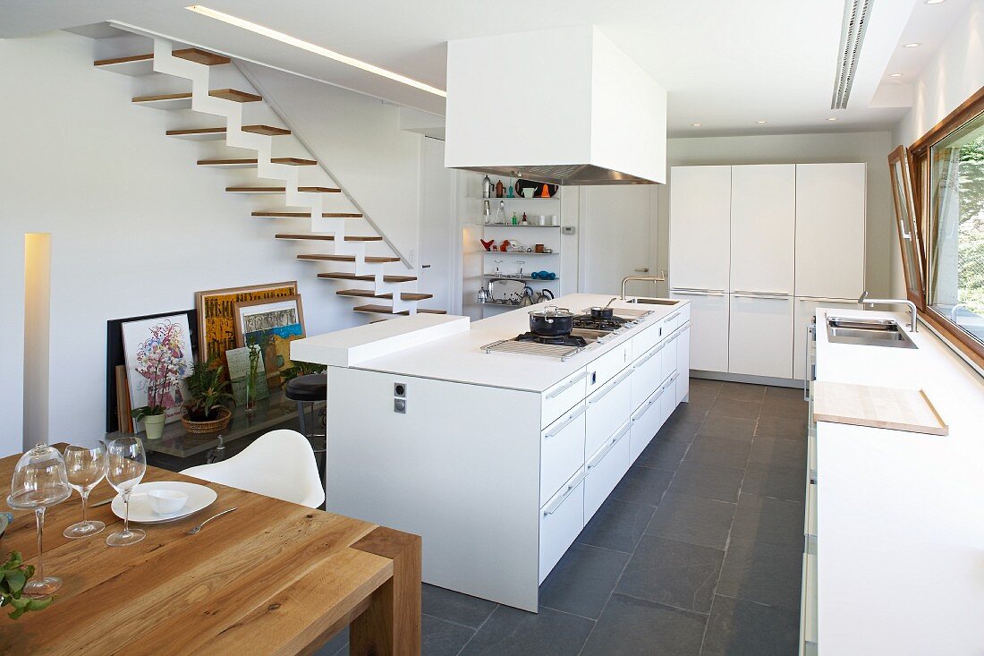 Purist designer kitchen in white with black slate floor