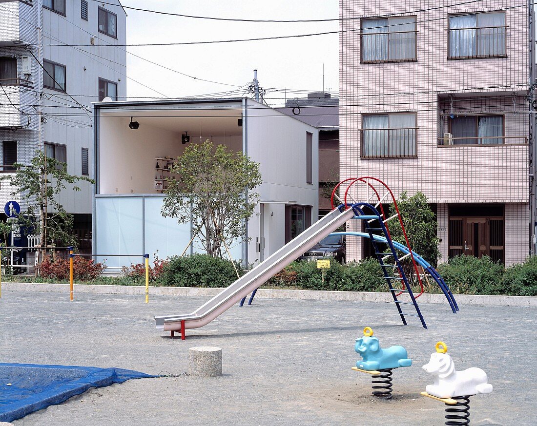 Children’s playground in front of modern houses and contemporary house with large window