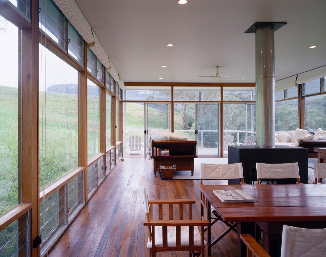 Naturnaher, offener Wohnraum mit Holztisch und großem Ofen
