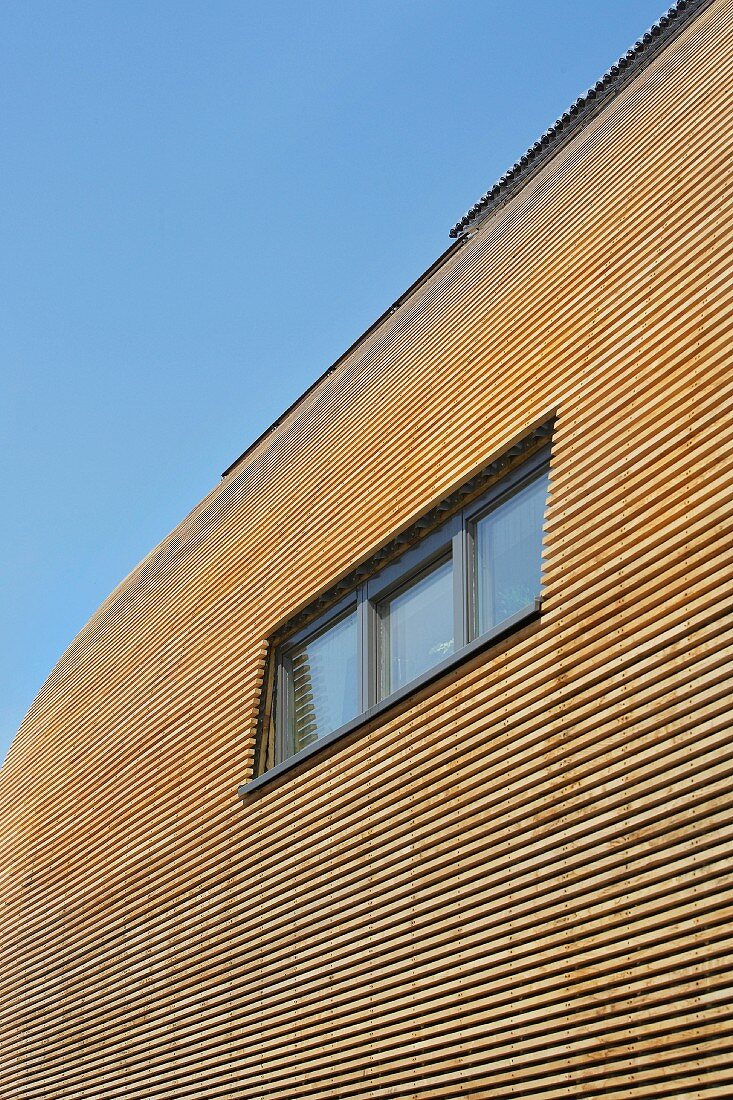 Öko-Hausfassade mit Fenster und Sonnenkollektoren