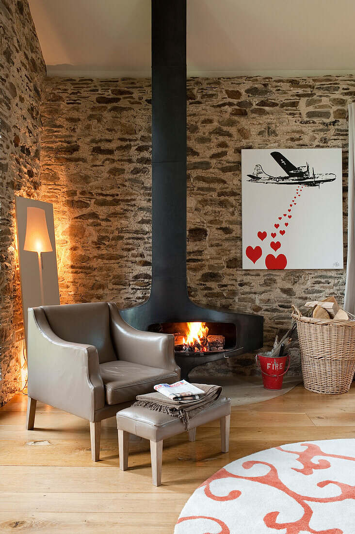 Rustic living area with modern fireplace and natural stone wall