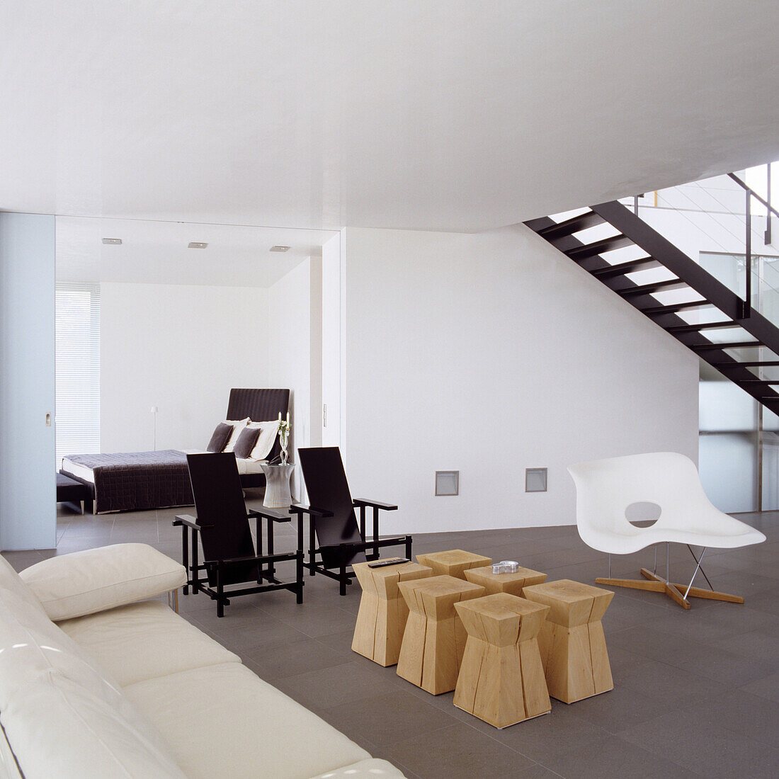 Minimalist living room with white designer chair and small wooden side tables