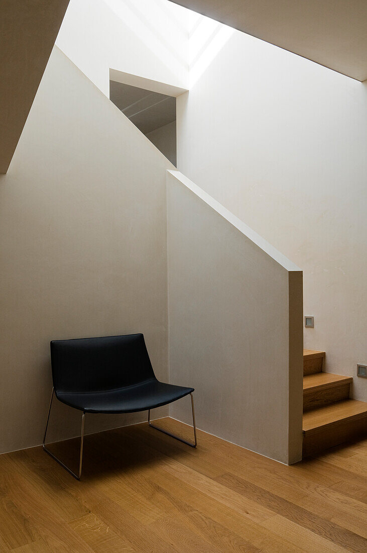 Modern staircase with minimalist rest area and skylight