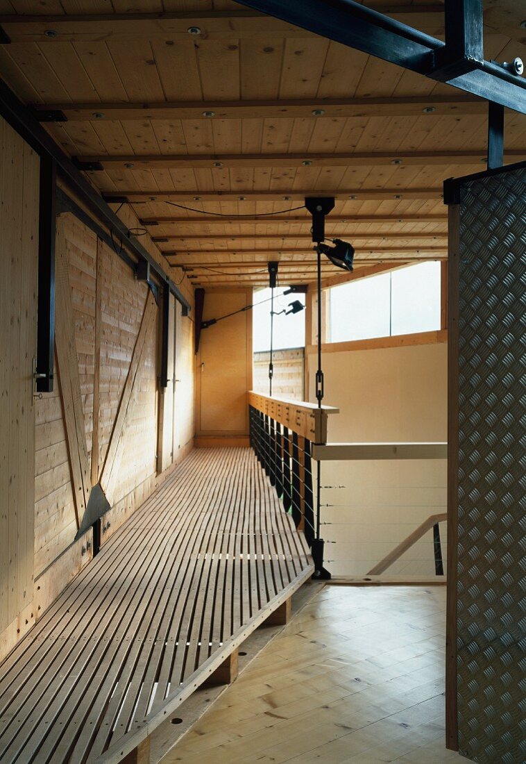 Gallery walkway in contemporary wooden house with steel structure